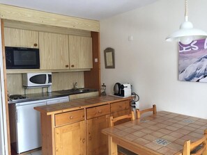 A compact kitchen with wooden cabinets, a microwave, a toaster, and a sink. - 3rd floor, balcony, tv, ski locker, 25m², Flaine (Flaine)