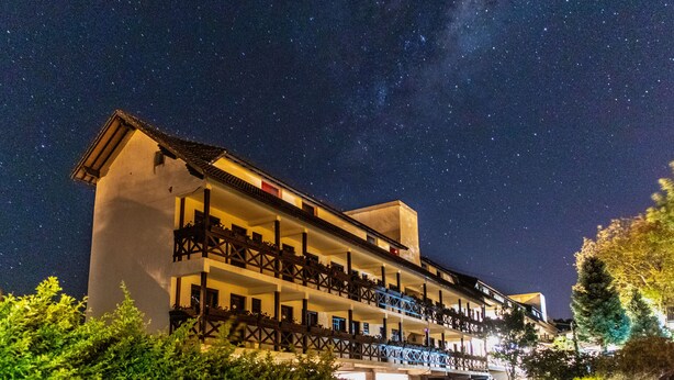 A multi-story hotel with balconies, under a starry night sky. - Hotel Pousada dos Plátanos (Nova Petropolis)