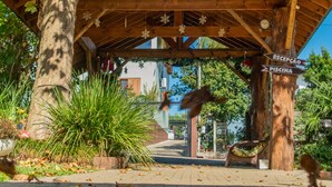 A wooden pavilion with a sign indicating 'RECEPCAO' and 'PISCINA'. - Hotel Pousada dos Plátanos (Nova Petropolis)