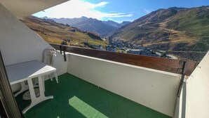 Un balcon avec vue sur les montagnes et la ville.
