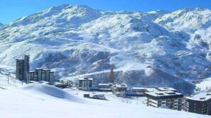 A snow-covered mountain with a town in the foreground. - 20m from shops, 4th floor, view street, balcony, tv, ski locker, 25m², Les Menuires (Les Menuires)