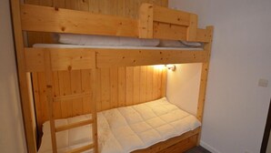 Ein Stockbett mit Holz Kopfteil und einer Leiter.
