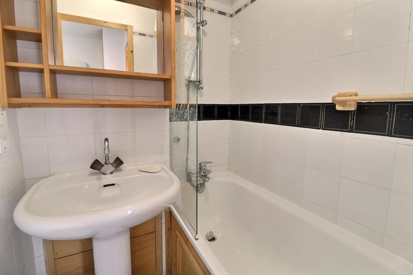 A bathroom with a white sink, a glass-enclosed shower, and a bathtub.
