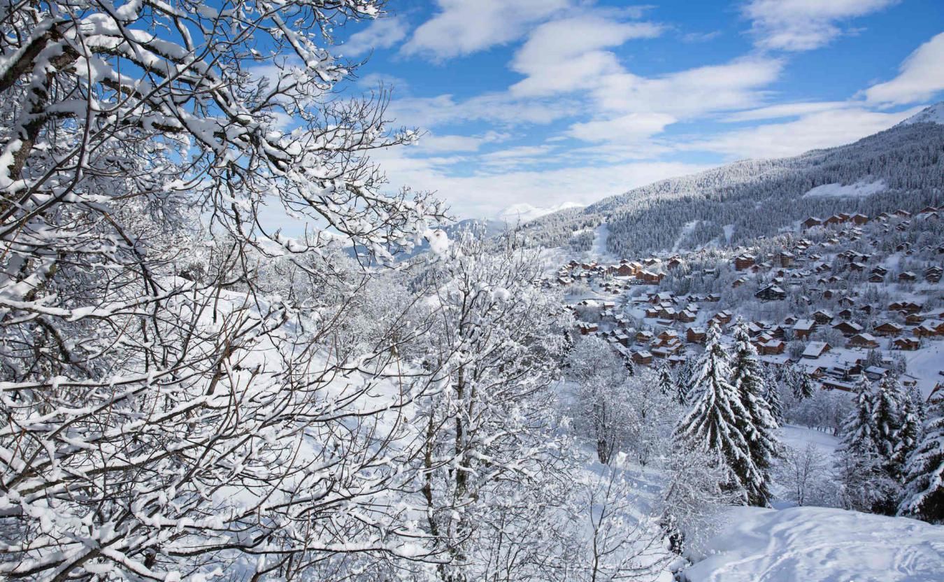 A snow-covered mountain landscape with a cluster of cabins.