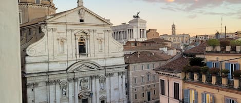 A view of a city street with historic buildings, including a prominent church with classical architecture.