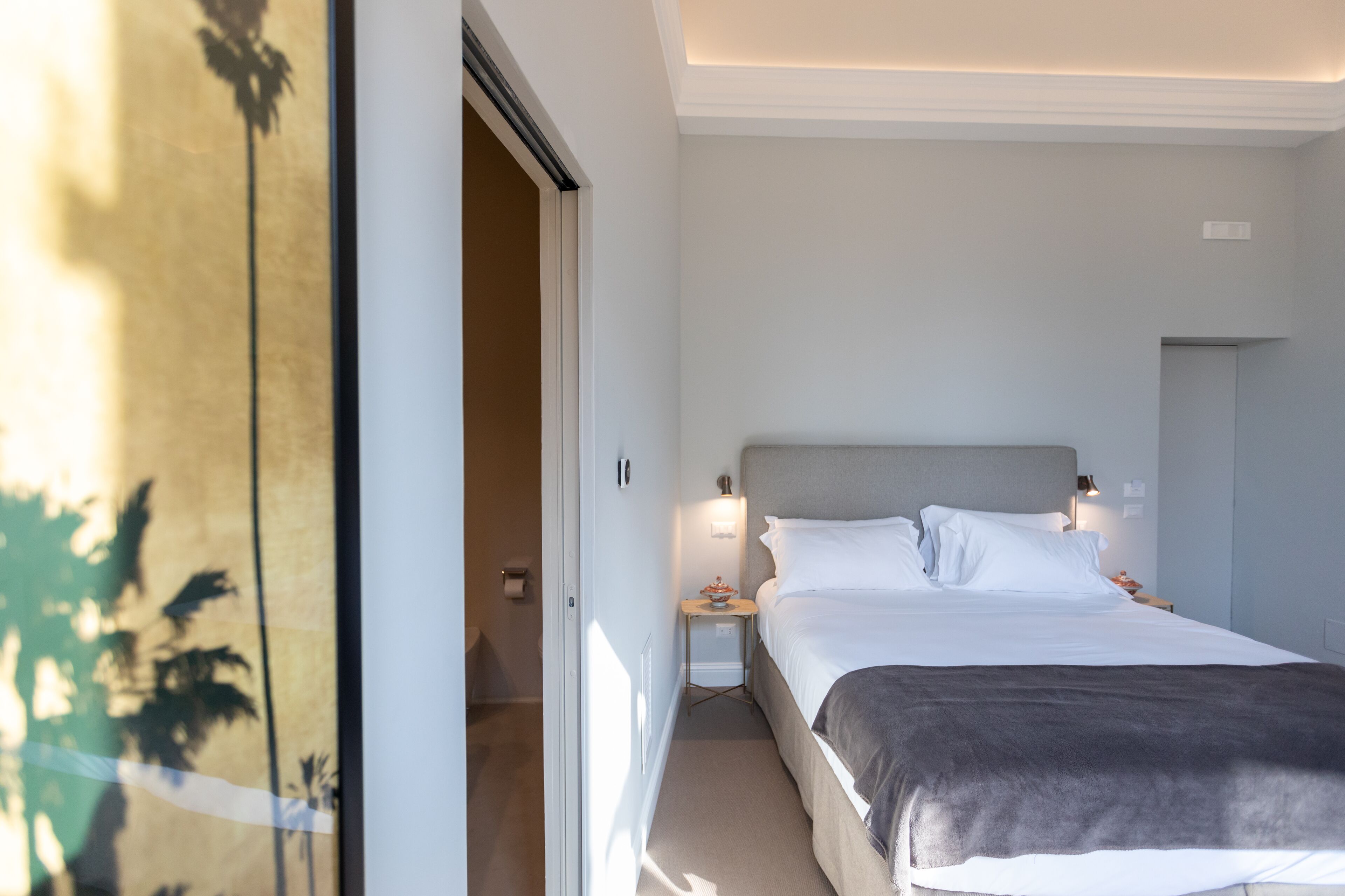 Een hotelkamer met een bed, nachtkastje en een bedtafel.