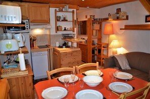 Cozy living space with kitchenette, dining area, and sofa, perfect for small gatherings.