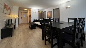 A modern living room with a dining area, wooden flooring, and a sofa. - 5th floor, balcony, tv, 56m², Brides Les Bains (Brides-les-Bains)
