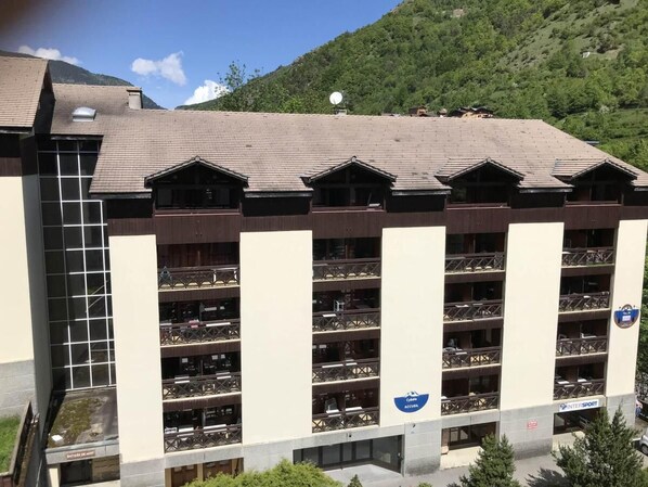 A multi-story building with a row of balconies, a ski lift, and a mountainous backdrop. - 2nd floor, balcony, tv, 28m², Brides Les Bains (Brides-les-Bains)
