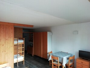 A compact room with a bunk bed, a dining table with chairs, a television, and a wardrobe. - 50m from ski slopes, 1st floor, view valley, tv, 28m², Les Arcs (Les Arcs)