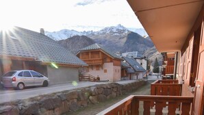 A balcony with a view of a mountain range, a parked car, and traditional wooden buildings. - 230m from ski slopes, 2nd floor, balcony, tv, ski locker, 22m², Valloire (Valloire)