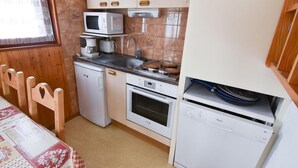 A compact kitchen with a microwave, coffee maker, oven, and dishwasher. - 230m from ski slopes, 2nd floor, balcony, tv, ski locker, 22m², Valloire (Valloire)