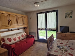 A cozy room with a bed, a dining table, and a TV. - 350m from ski lifts, 2nd floor, terrace, parking, tv, ski locker, 25m², Valloire (Valloire)