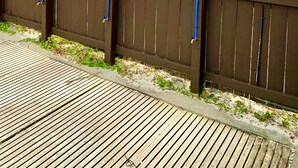 Une terrasse en bois offrant une vue sur la plage et sur une étendue d’eau.