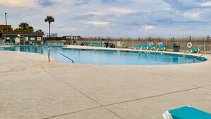 Une piscine équipée de chaises longues et d’un poste de surveillance pour les sauveteurs.