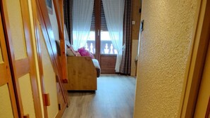 A wooden staircase leading to a room with a bed and a window with curtains. - Resort center, 1st floor, balcony, parking, tv, ski locker, 31m², Valloire (Valloire)