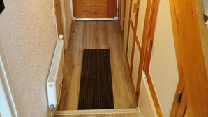 A wooden staircase leading to a room with a door, a radiator, and a mat. - Resort center, 1st floor, balcony, parking, tv, ski locker, 31m², Valloire (Valloire)