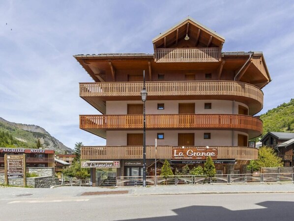 A multi-story building with balconies, a sign for 'La Grange,' and a restaurant named 'La Cremerie.'