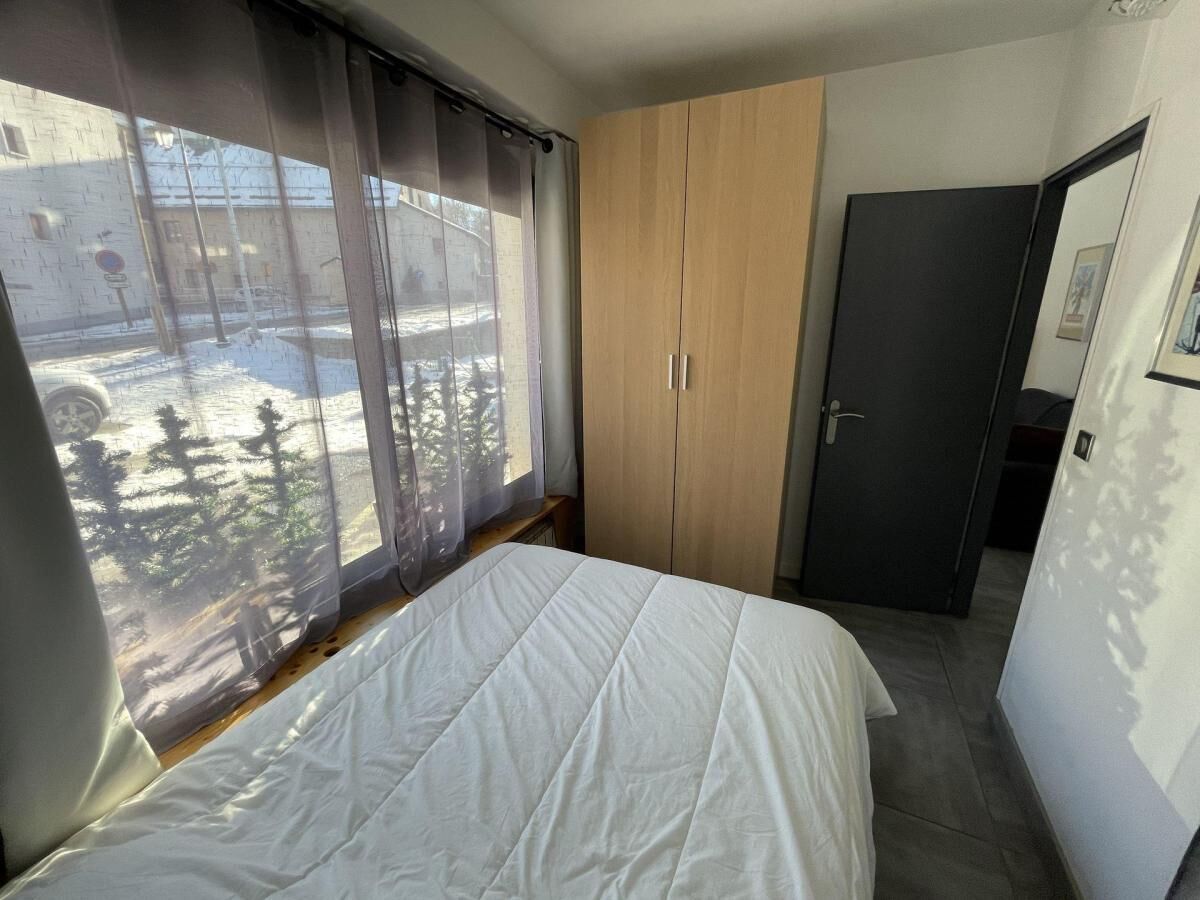 A bedroom with a bed, a wardrobe, and a door.