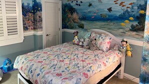A bedroom with a bed, a ceiling fan, and a mural of an underwater scene. - Luxury Penthouse 4BR Condo - Great for Families! (North Myrtle Beach)