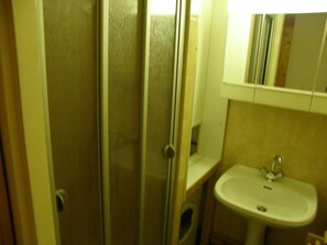 A bathroom with a glass shower door, a sink, and a mirror above the sink. - 1st floor, balcony, parking, 25m², Valloire (Valloire)