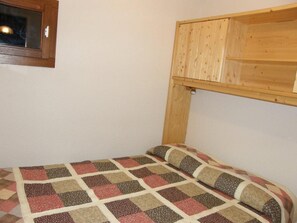 A small room with a single bed, a wooden headboard, and a window. - 1st floor, balcony, parking, 25m², Valloire (Valloire)