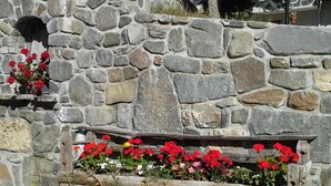 A stone wall with a wooden bench and flower boxes containing red flowers. - 1st floor, terrace, ski locker, 30m², Valloire (Valloire)