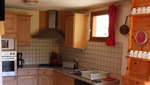 A compact kitchen with wooden cabinets, a microwave, a toaster, and a sink. - 2nd floor, balcony, ski locker, 92m², Valloire (Valloire)