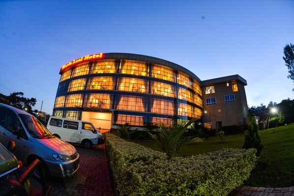 A hotel with a circular glass facade and a flat roof.