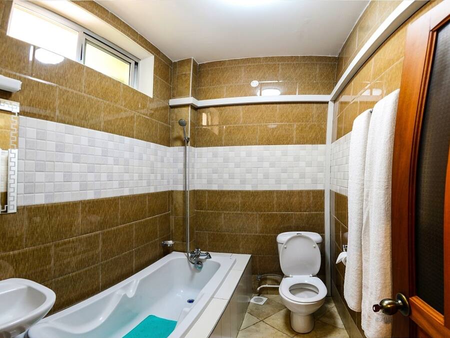 A bathroom with a bathtub, sink, toilet, and shower.