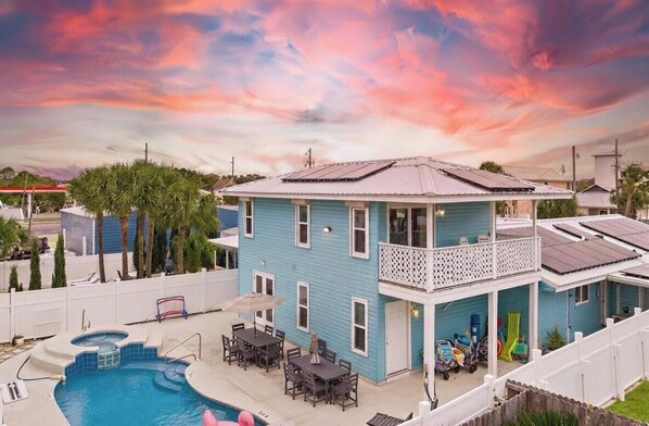Une maison à deux étages avec une piscine, un balcon et une cour arrière clôturée.