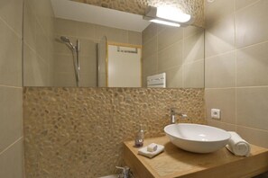 Ein Badezimmer mit Steinwand, Waschbecken und einem Spiegel darüber.