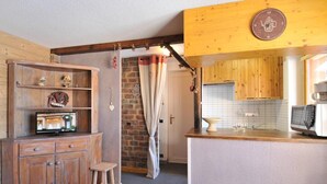 Eine rustikale Küche mit Holzsäulen, einer kleinen Bar und einer Ziegelwand.