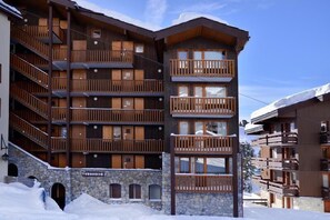 Un edificio de varios pisos con balcones de madera y muros de piedra, con la leyenda 'Turquoise'.