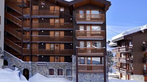 Un edificio de varios pisos con balcones de madera y muros de piedra, con la leyenda 'Turquoise'.