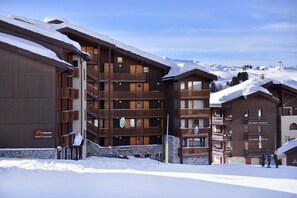 Ein mehrstöckiges Hotel mit hölzernen Balkonen und einem Steinsockel.