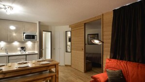 A compact living space with a kitchenette, a dining area, and a cozy seating area.