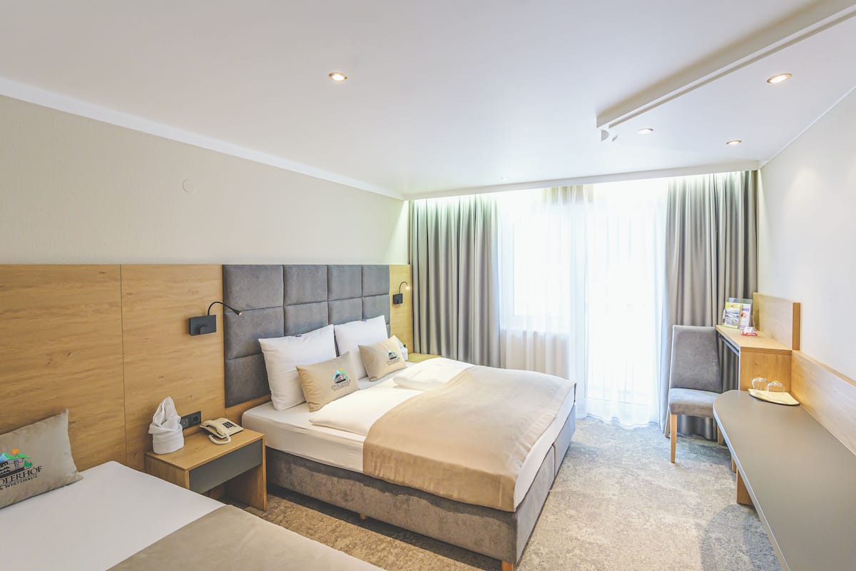 Moderni hotellihuone, jossa on suuri sänky, yöpöydät, työpöytä ja tuoli.
