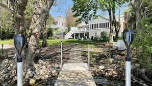 A pathway leading to a house with a porch and outdoor seating.