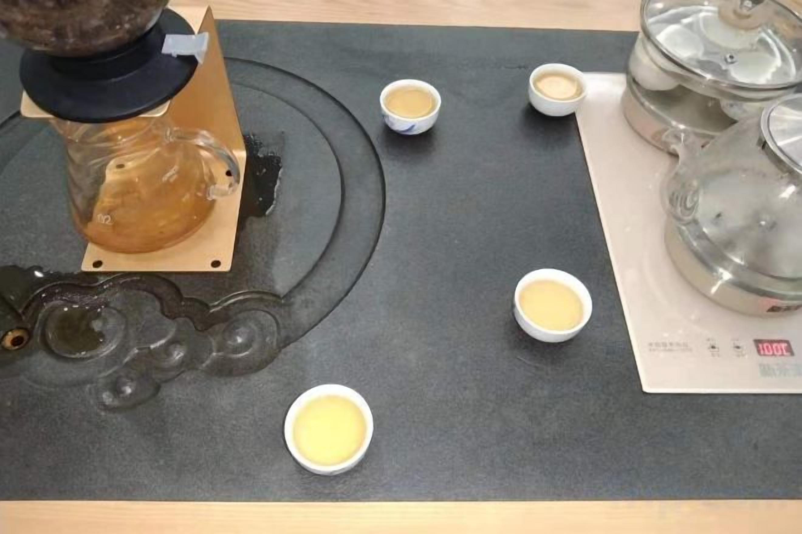 A coffee machine dispensing coffee into cups on a table.
