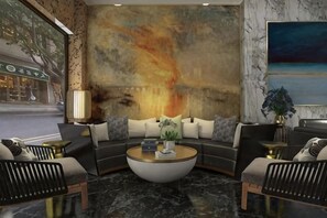 Un espace de détente moderne comprenant un ensemble de canapés, une table basse et un grand tableau abstrait accroché au mur.