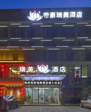 A hotel with a modern facade, illuminated signage, and a visible entrance. - Royal Hotel (Shenzhen)