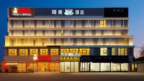A multi-story hotel with a modern facade, featuring signage for a restaurant and a hotel. - Royal Hotel (Shenzhen)