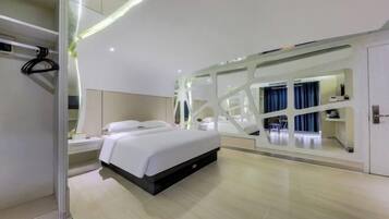 A modern hotel room with a bed, bedside table, and a large mirror.