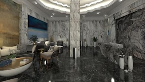 A modern lobby with a marble floor, a large column, and a painting on the wall. - Royal Hotel (Shenzhen)