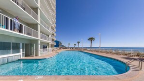 A swimming pool with a clear blue water, surrounded by a white building with balconies. - Gulf Views, Beach Chairs& Wagon, Steps to Pool& Beach, Spring Break Discount (Orange Beach)