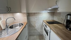 A compact kitchen with a sink, stove, and coffee maker. - 100m from ski slopes, 8th floor, view ski slopes, balcony, tv, ski locker, 28m², La Plagne (La Plagne)