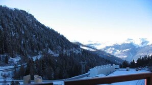 A mountain view from a balcony with a wooden railing, snow-covered ground, and a clear sky. - 100m from ski lifts, 7th floor, balcony, tv, ski locker, 15m², La Plagne (La Plagne)