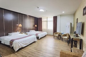 A hotel room with two beds, a TV, a desk, and a chair.