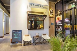 A restaurant with a chalkboard menu, outdoor seating, and a sign above the entrance. - Bati Yangguang Chain Hotel Meizhou Meilong (Meizhou)